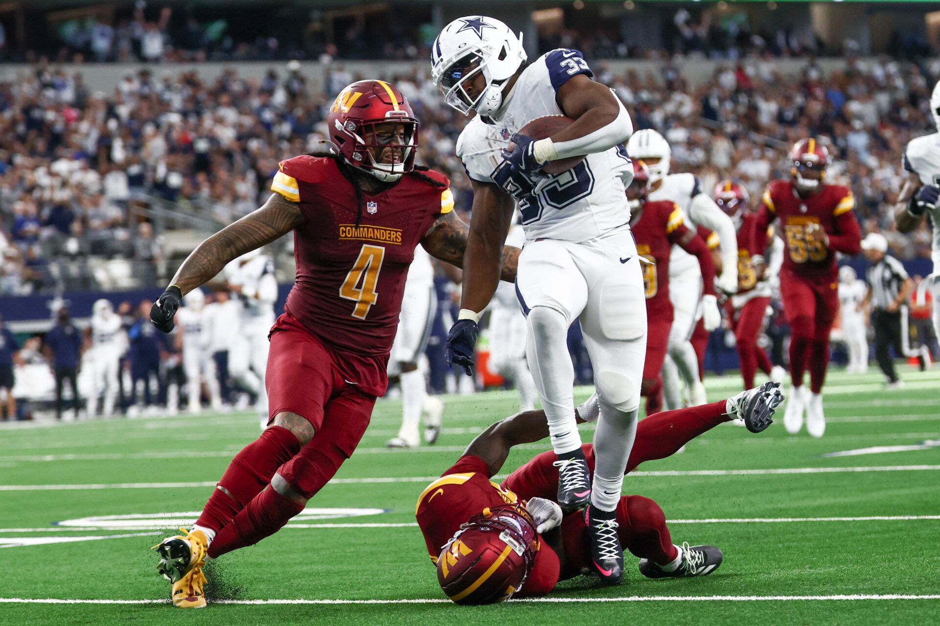 Dallas Cowboys running back Javonte Williams (33) avoids a tackle by Dallas Cowboys cornerback Kaiir Elam (20) during the second quarter of the game at AT&T Stadium.