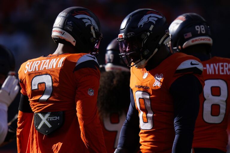 Denver Broncos cornerback Pat Surtain II (2) and linebacker Jonathon Cooper (0) before the game at Empower Field at Mile High.