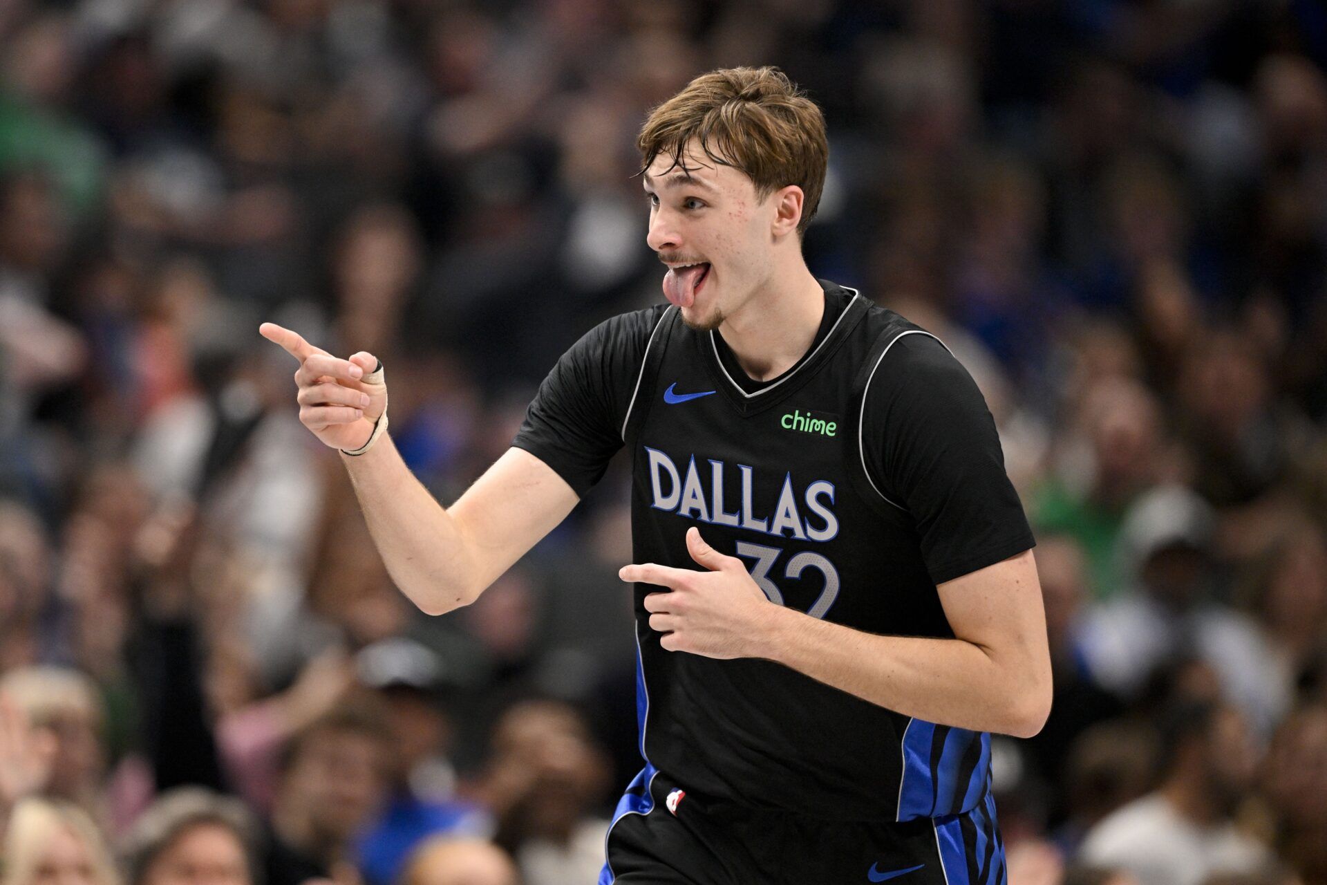 Dallas Mavericks forward Cooper Flagg (32) points to his team bench as he celebrates scoring against the Denver Nuggets during the second quarter at the American Airlines Center.