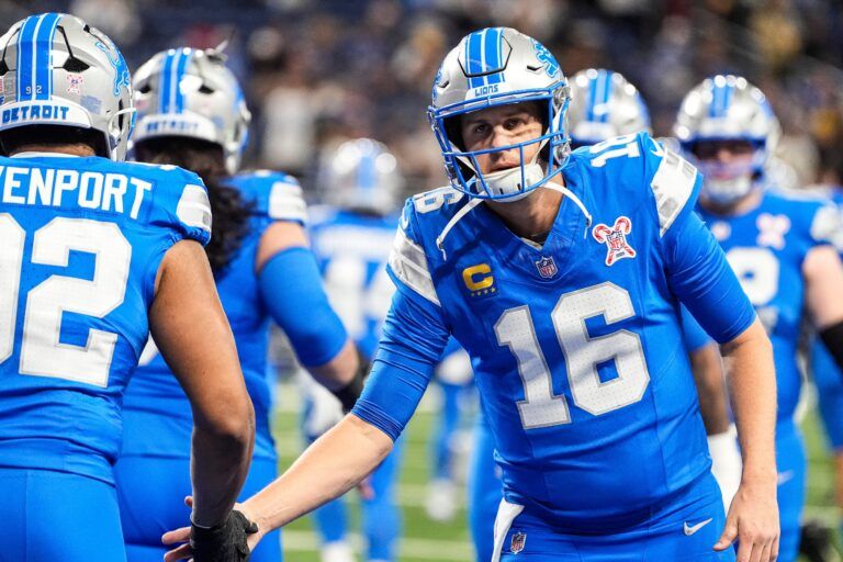 Detroit Lions quarterback Jared Goff (16) shakes hands with defensive end Marcus Davenport (92) during warm up at Ford Field in Detroit on Sunday, Dec. 21, 2025.