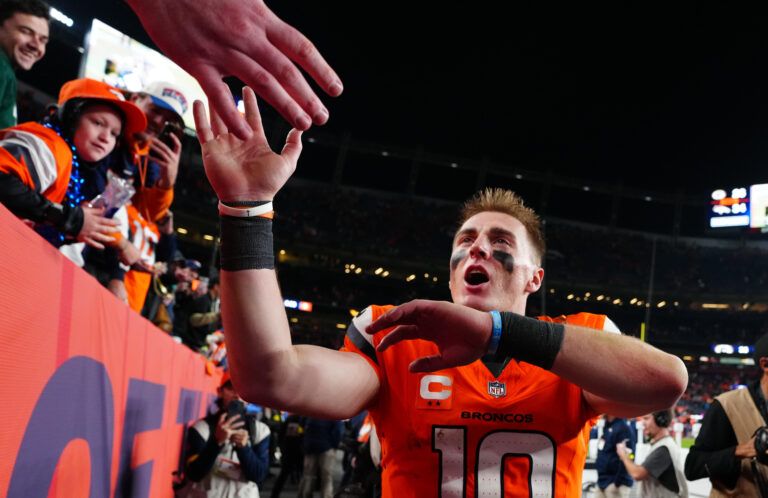 Denver Broncos quarterback Bo Nix (10) high-fives fans after defeating the Green Bay Packers at Empower Field at Mile High.