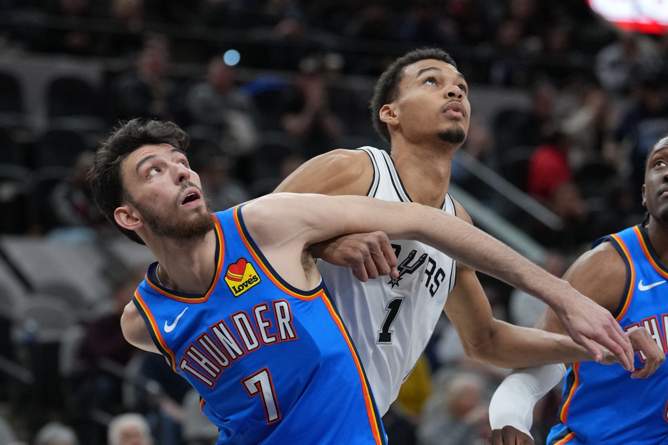 Oklahoma City Thunder forward Chet Holmgren (7) and San Antonio Spurs center Victor Wembanyama (1) battle for position in the first half at Frost Bank Center.