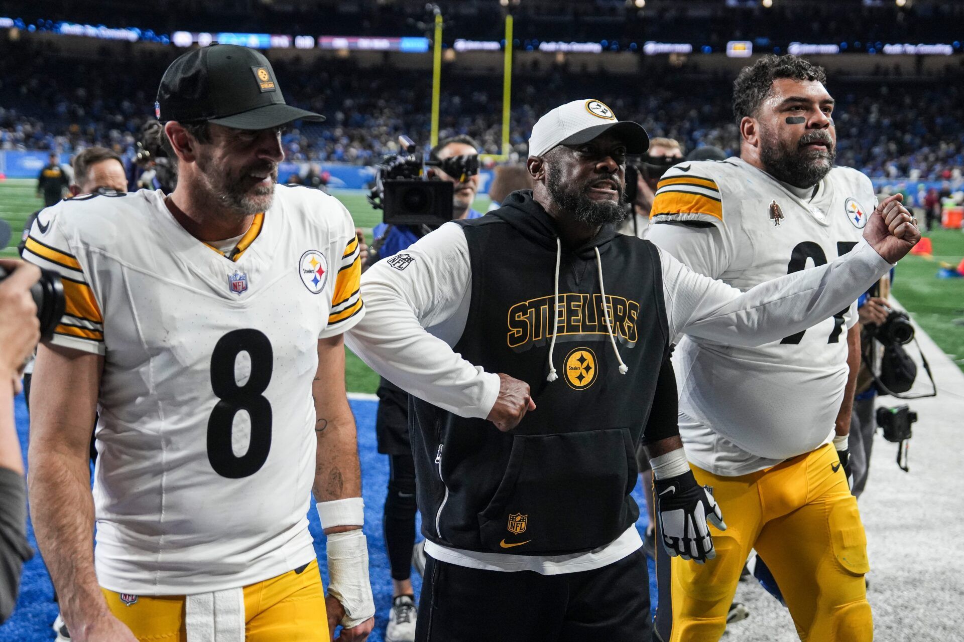 Pittsburgh Steelers coach Mike Tomlin celebrates as he walks off the field with quarterback Aaron Rodgers and defensive tackle Cameron Heyward after a 29-24 win over the Detroit Lions at Ford Field in Detroit on Sunday, Dec. 21, 2025.