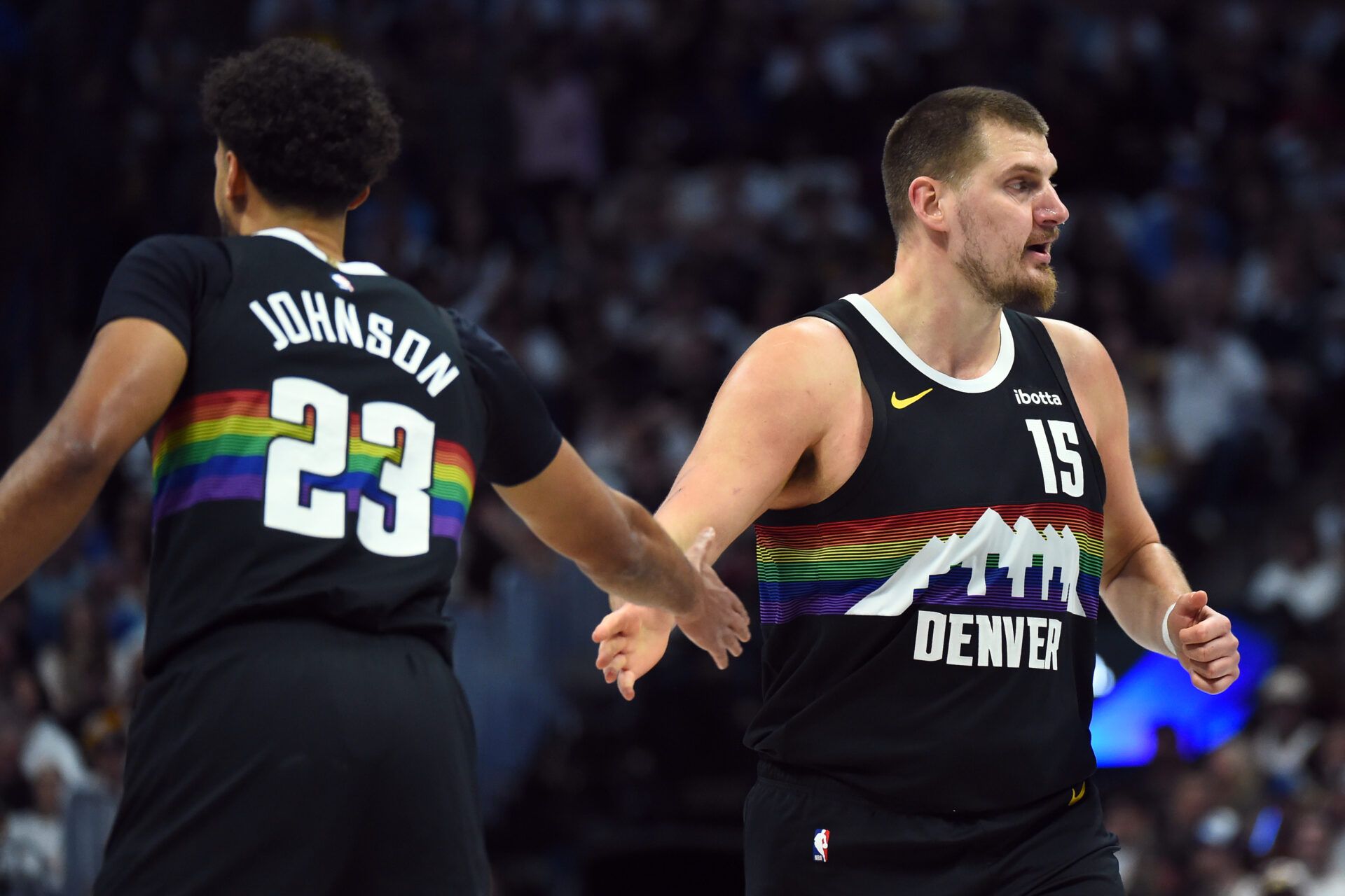 Denver Nuggets center Nikola Jokic (15) is congratulated by forward Cameron Johnson (23) after a basket during the first half against the Houston Rockets at Ball Arena.