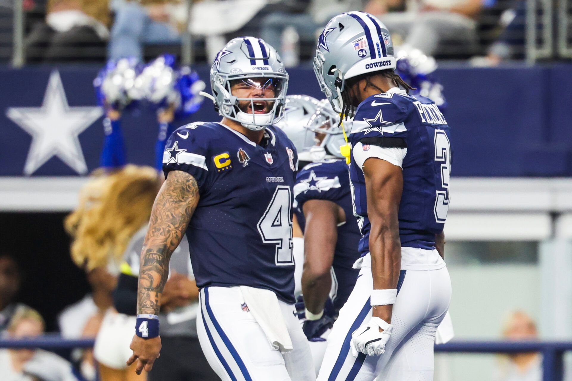Dallas Cowboys quarterback Dak Prescott (4) celebrates with wide receiver George Pickens (3) following a touchdown pass caught by Pickens during the second quarter at AT&T Stadium.