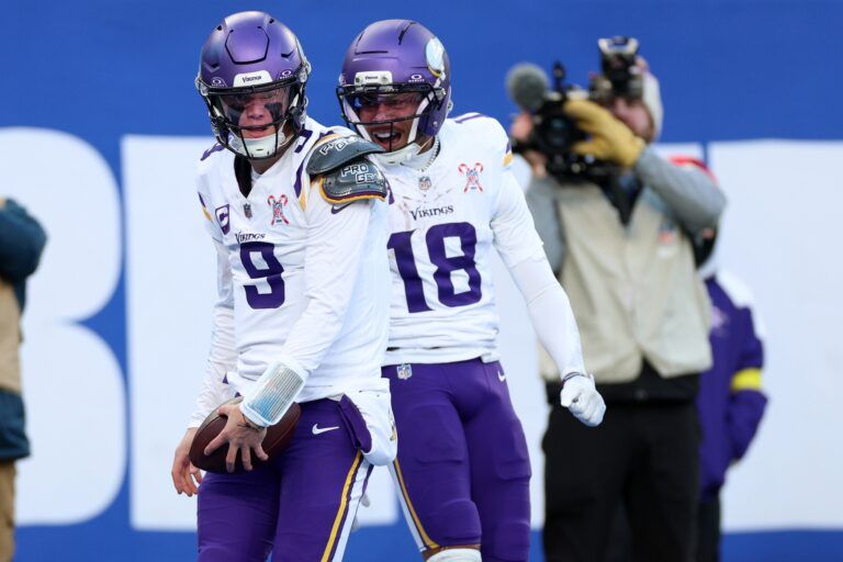 Minnesota Vikings quarterback J.J. McCarthy (9) reacts with wide receiver Justin Jefferson (18) after rushing for a touchdown against the New York Giants during the first half at MetLife Stadium.