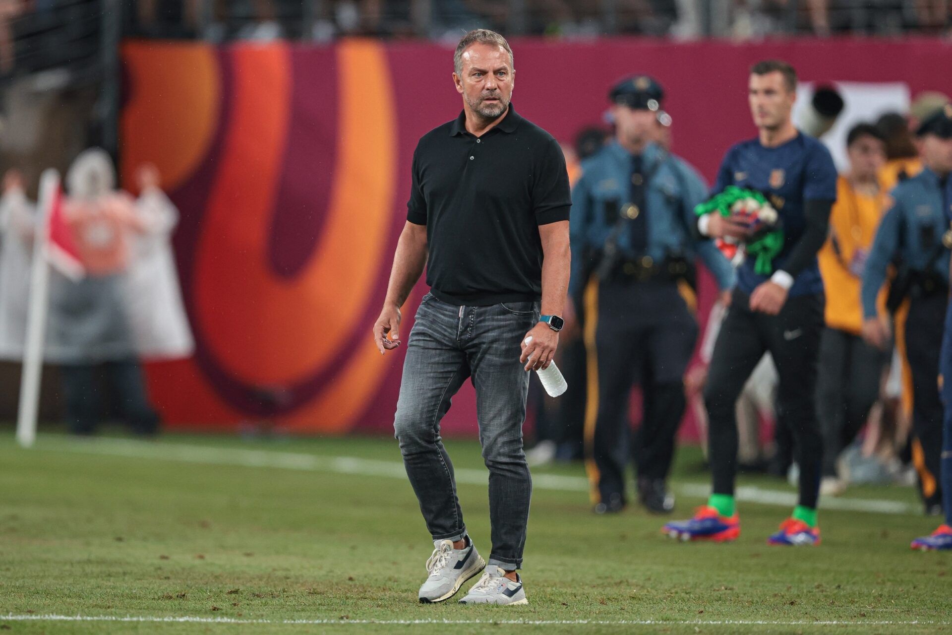 Barcelona head coach Hansi Flick walks off the pitch during a weather delay during an international friendly against Real Madrid at MetLife Stadium.