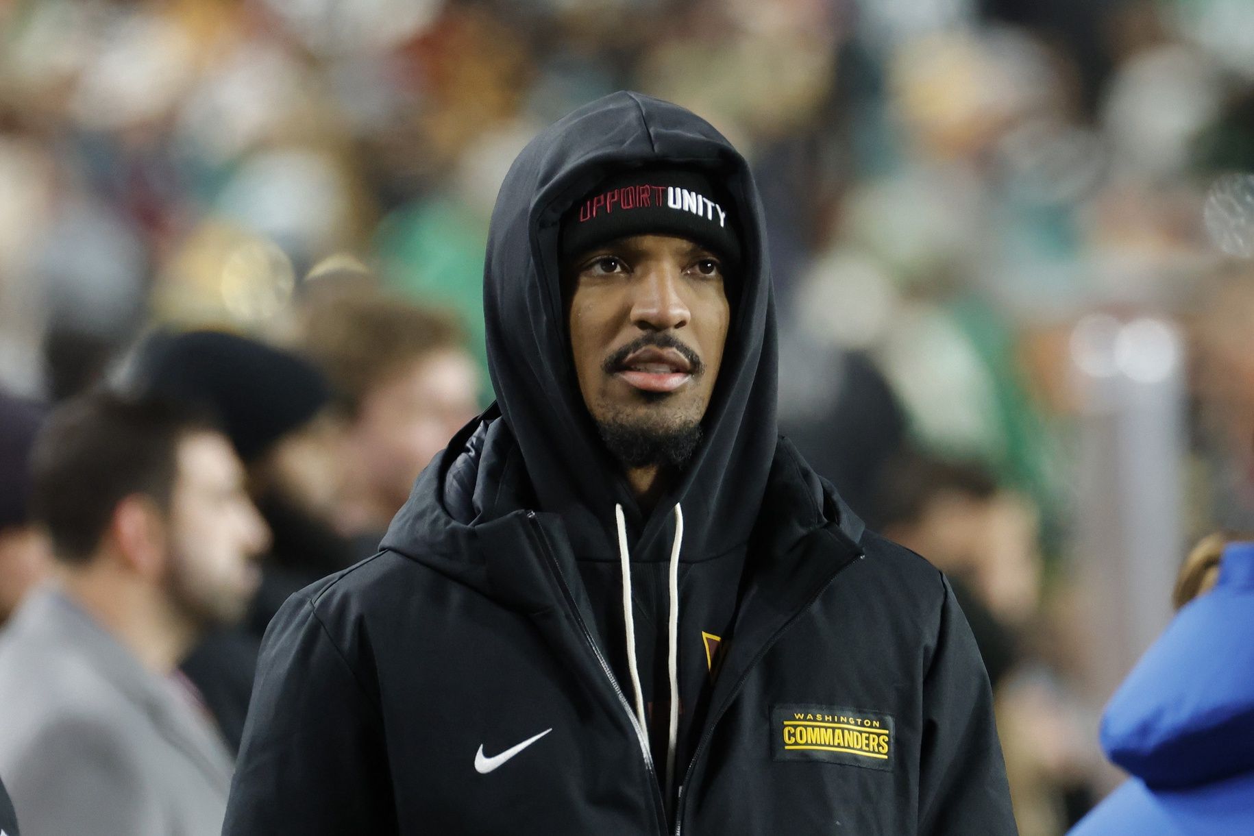 Washington Commanders quarterback Jayden Daniels (5) looks on from the sidelines during the final minutes of the second half against the Philadelphia Eagles at Northwest Stadium.
