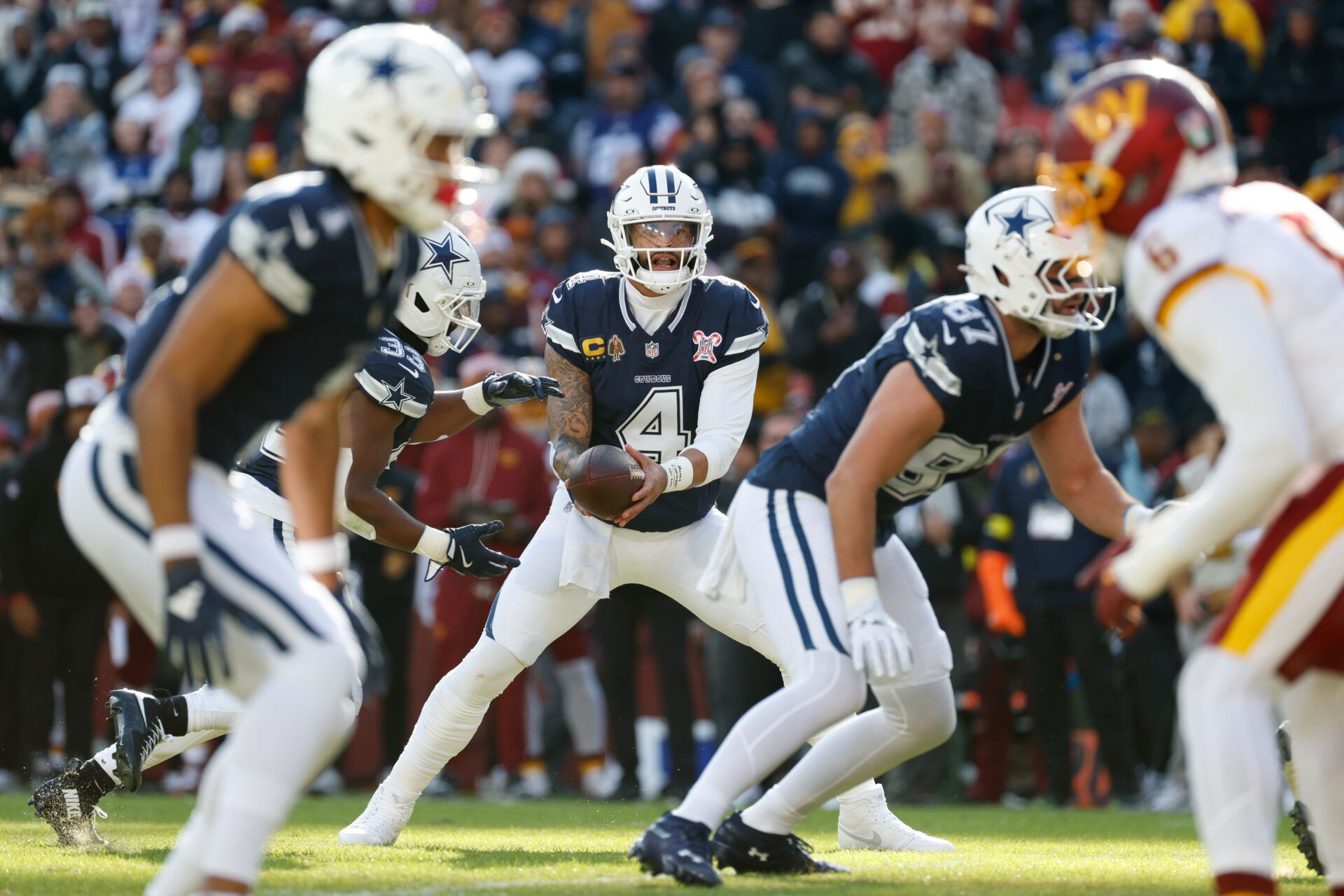 Dallas Cowboys quarterback Dak Prescott (4) looks to hand off the ball to running back Javonte Williams (33) against the Washington Commanders in the first quarter at Northwest Stadium.