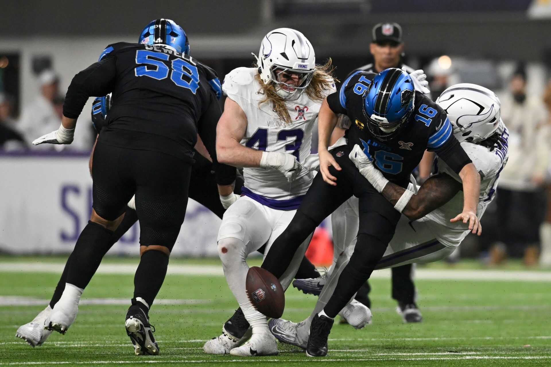 Detroit Lions quarterback Jared Goff (16) fumbles the ball defended by Minnesota Vikings linebacker Andrew van Ginkel (43) and linebacker Dallas Turner (15) in the fourth quarter at U.S. Bank Stadium.