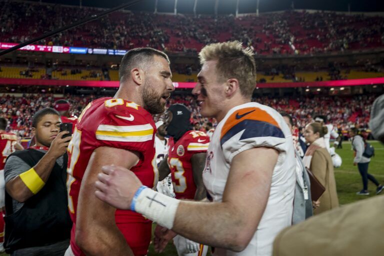Denver Broncos quarterback Bo Nix (10) and Kansas City Chiefs tight end Travis Kelce (87) after the game at GEHA Field at Arrowhead Stadium.