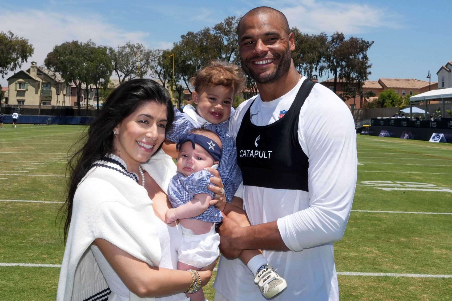 Dallas Cowboys quarterback Dak Prescott poses with fiancee Sarah Jane Ramos and daughters MJ Rose Prescott and Aurora Prescott at training camp at the River Ridge Fields.