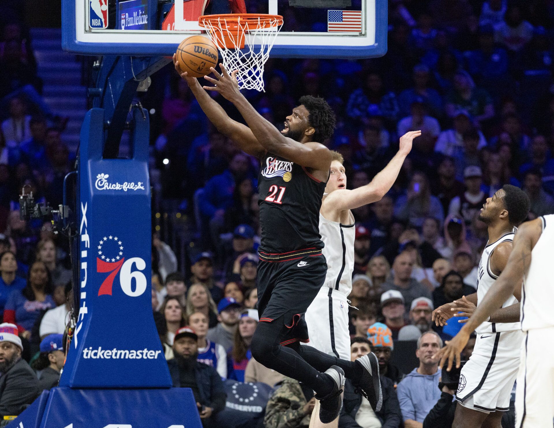 Philadelphia 76ers center Joel Embiid (21) drives for a shot past Brooklyn Nets forward Danny Wolf (2) during the second quarter at Xfinity Mobile Arena.