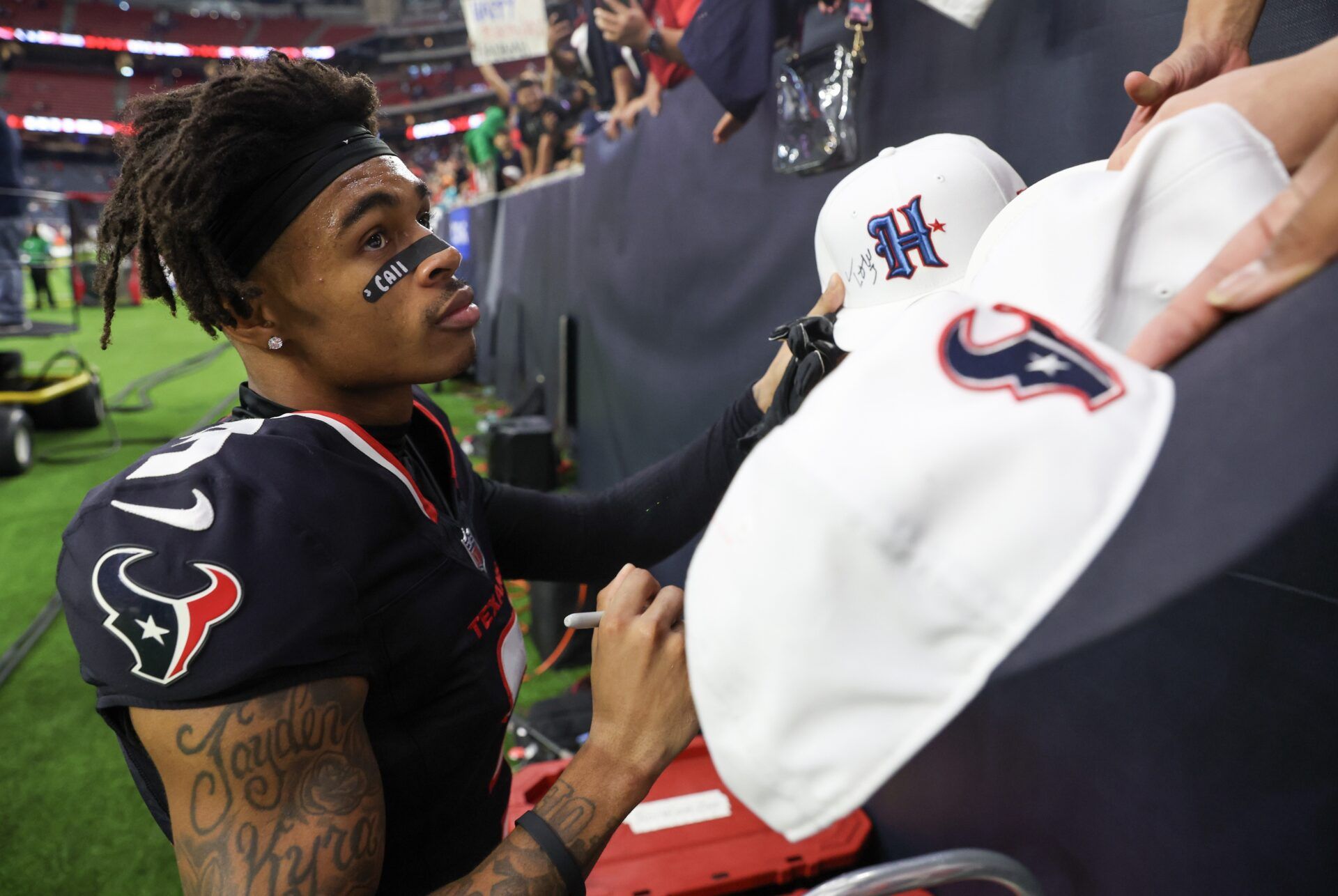 Houston Texans wide receiver Tank Dell (3) signs autographs after defeating the Miami Dolphins at NRG Stadium.