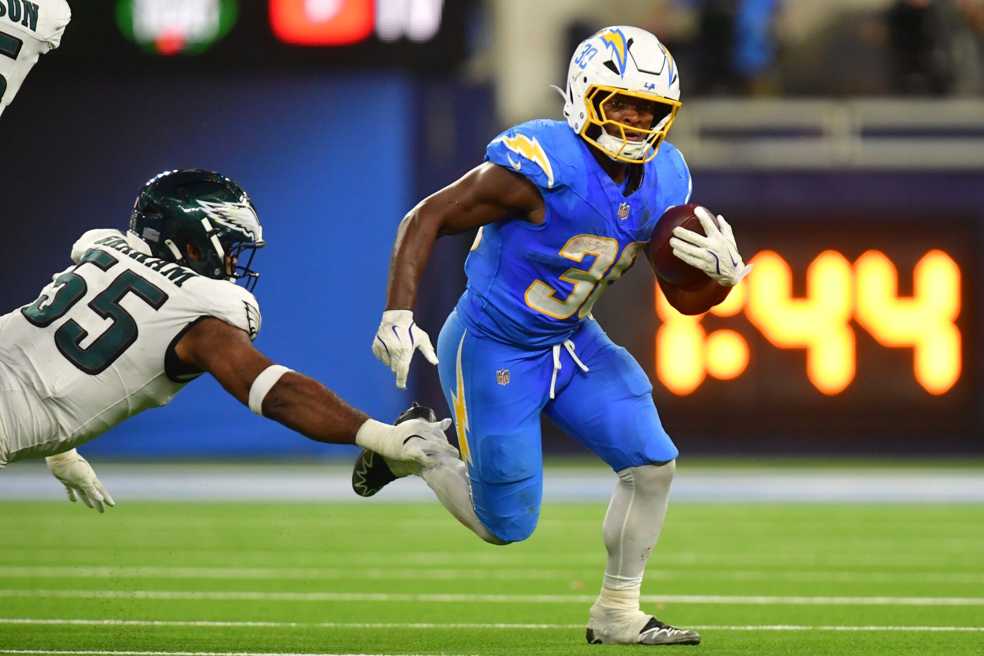 Los Angeles Chargers running back Kimani Vidal (30) runs against Philadelphia Eagles defensive end Brandon Graham (55) in the second half at SoFi Stadium.