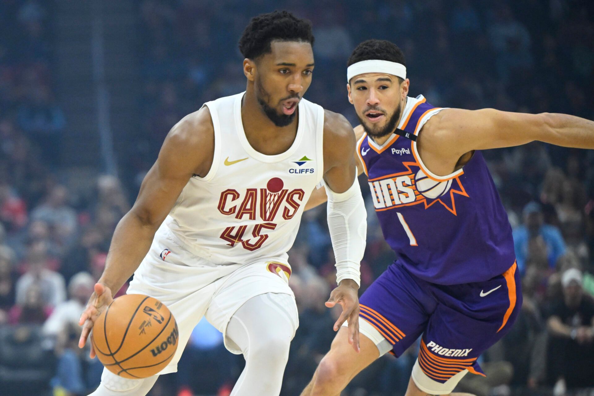 Cleveland Cavaliers guard Donovan Mitchell (45) dribbles beside Phoenix Suns guard Devin Booker (1) in the first quarter at Rocket Mortgage FieldHouse.