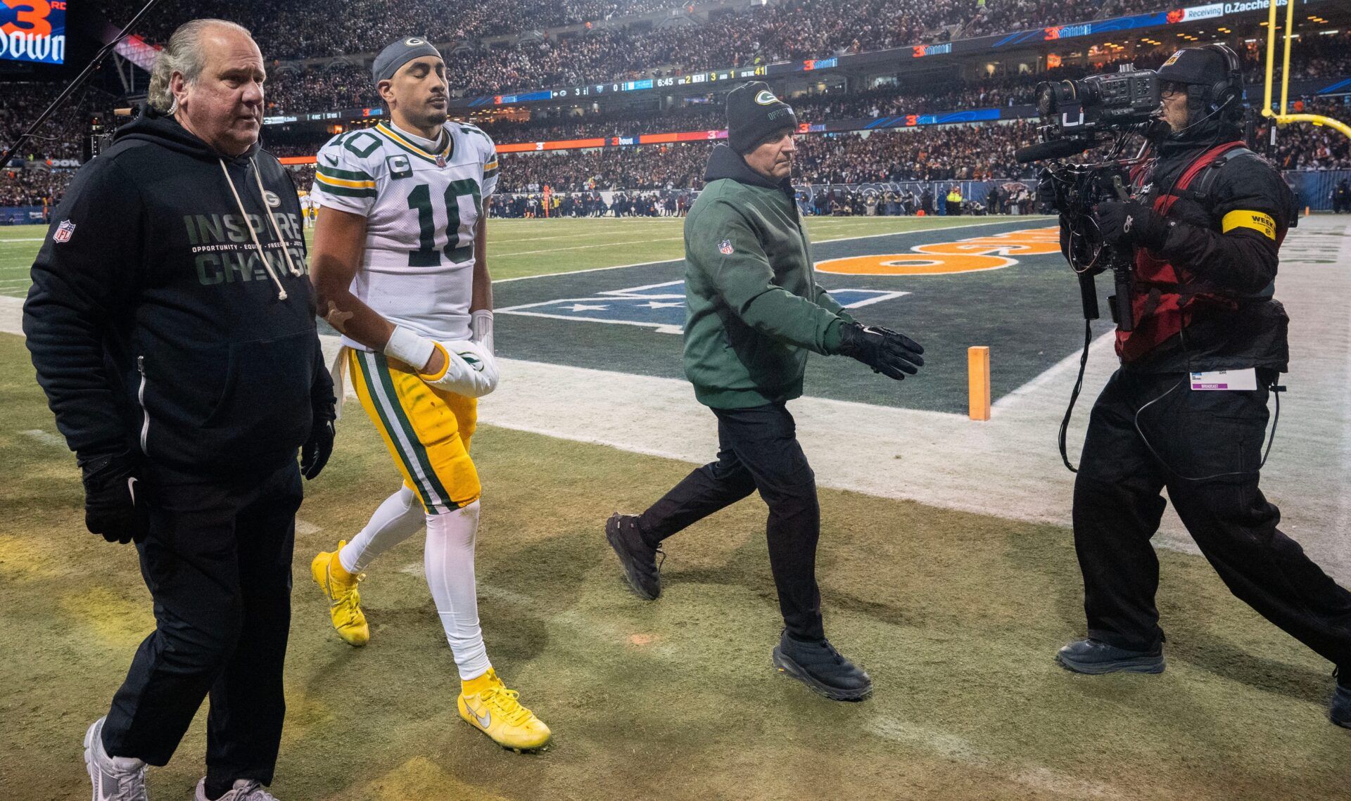 Green Bay Packers quarterback Jordan Love (10) is escorted to the locker room after suffering a concussion during the first quarter of their game against the Chicago Bears Saturday, December 20, 2025 at Soldier Field in Chicago, Illinois.