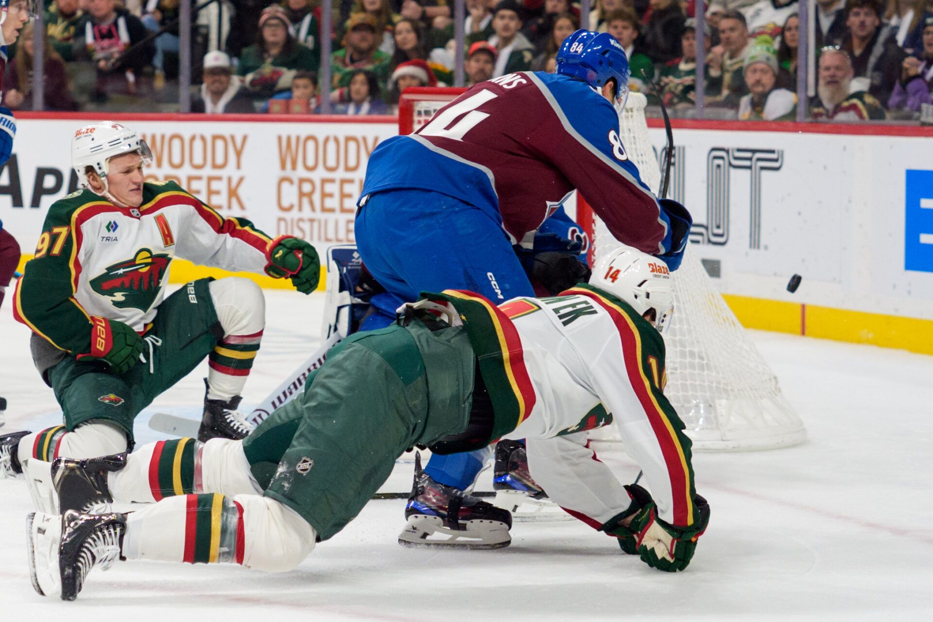 Minnesota Wild center Joel Eriksson Ek (14) dives around Colorado Avalanche defenseman Brent Burns (84) to play the puck in the third period at Grand Casino Arena.