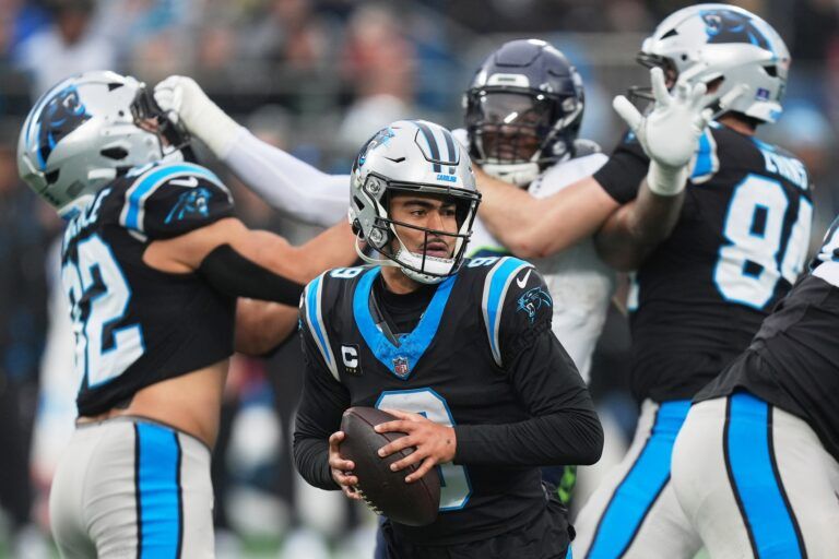 Carolina Panthers quarterback Bryce Young (9) looks to throw a pass as tight ends Tommy Tremble (82) and Mitchell Evans (84) block against Seattle Seahawks defensive end Leonard Williams (99) during the third quarter at Bank of America Stadium.