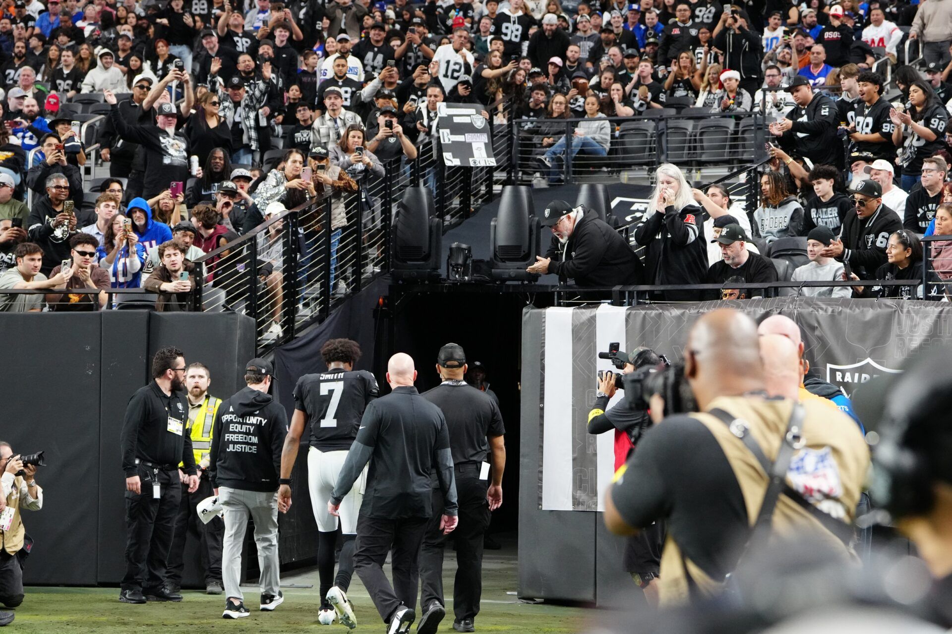Las Vegas Raiders quarterback Geno Smith (7) is helped off the field in the fourth quarter against the New York Giants at Allegiant Stadium.