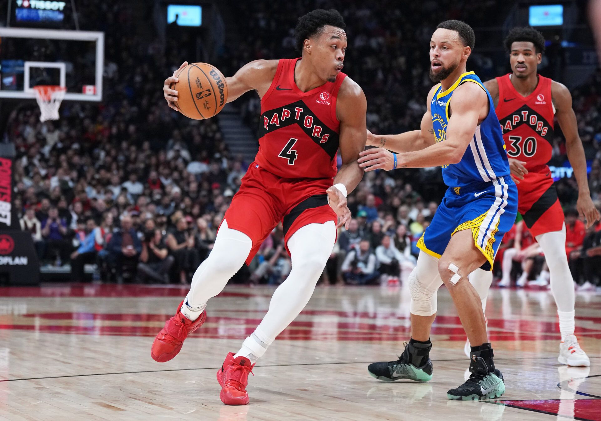 Toronto Raptors forward Scottie Barnes (4) controls the ball as Golden State Warriors guard Stephen Curry (30) tries to defend during the second quarter at Scotiabank Arena.