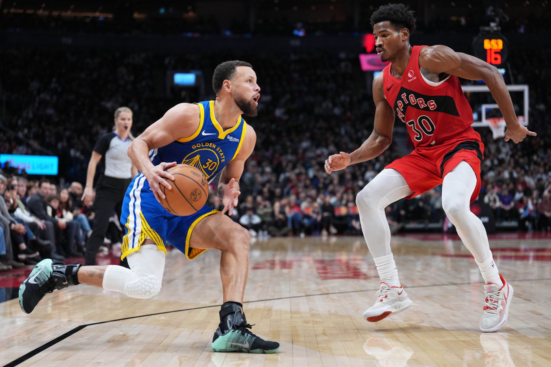 Golden State Warriors guard Stephen Curry (30) controls the ball as Toronto Raptors guard Ochai Agbaji (30) tries to defend during the third quarter at Scotiabank Arena.