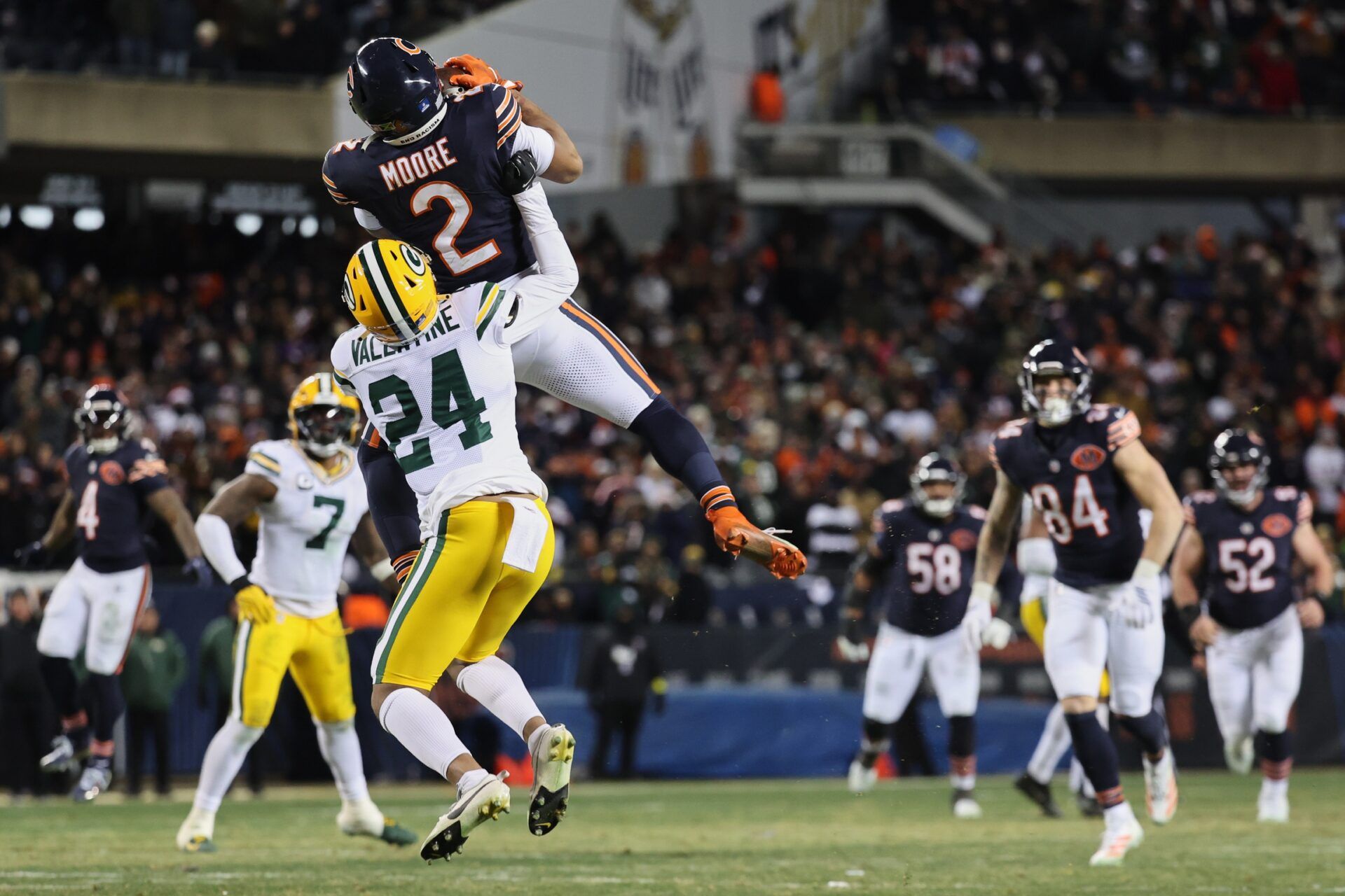 Chicago Bears wide receiver DJ Moore (2) leaps to catch a pass thrown by quarterback Caleb Williams (not pictured) against Green Bay Packers cornerback Carrington Valentine (24) during overtime at Soldier Field.