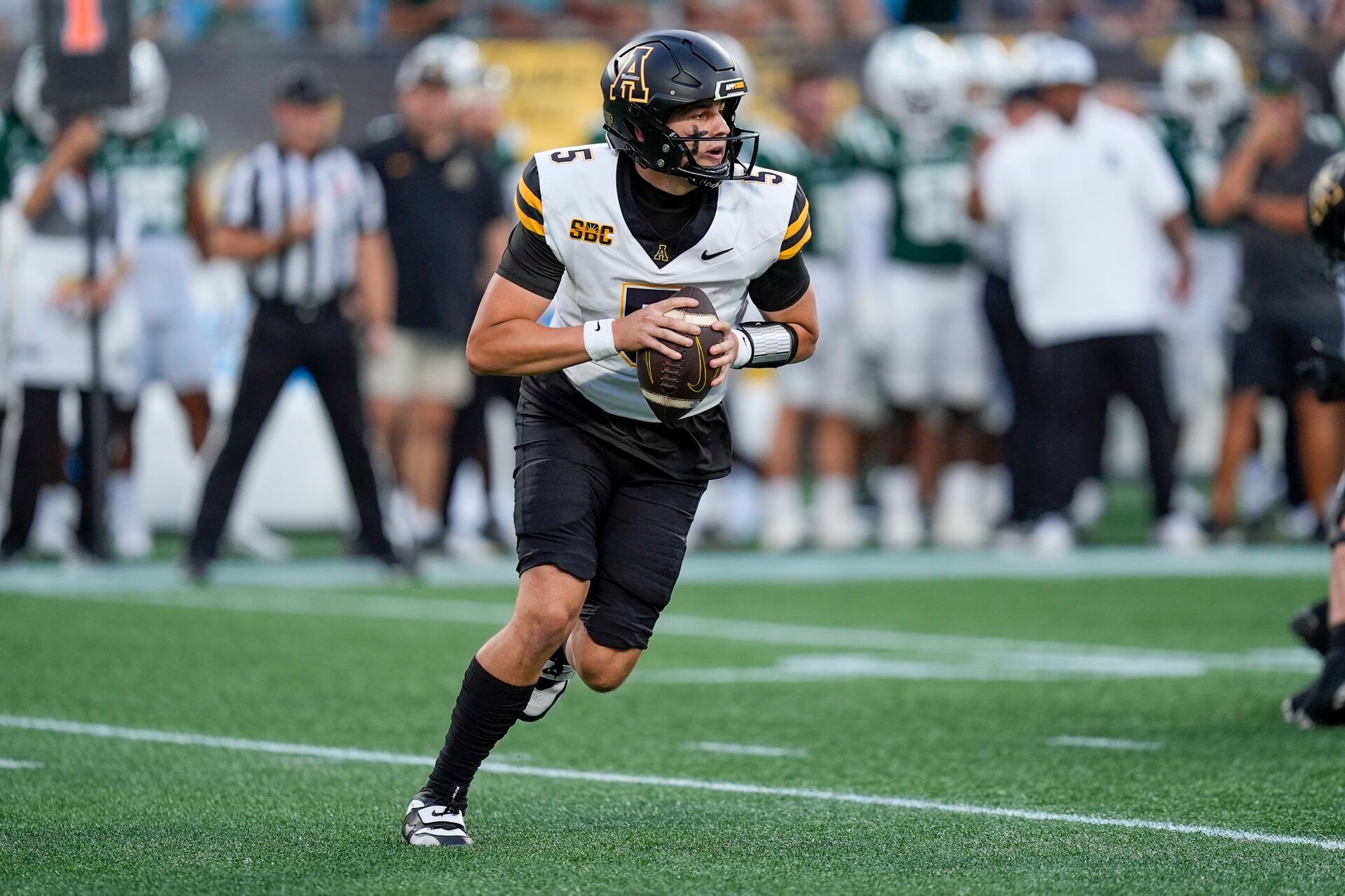 Appalachian State Mountaineers quarterback AJ Swann (5) rolls out to pass against the Charlotte 49ers during the first quarter at Bank of America Stadium.