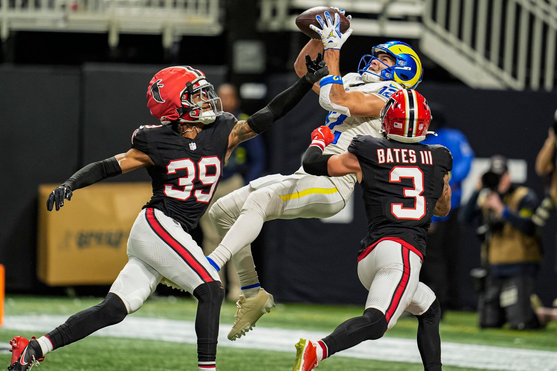 Los Angeles Rams wide receiver Puka Nacua (12) catches a touchdown pass over Atlanta Falcons cornerback C.J. Henderson (39) and safety Jessie Bates III (3) on a play later called back for a holding penalty during the second half at Mercedes-Benz Stadium.