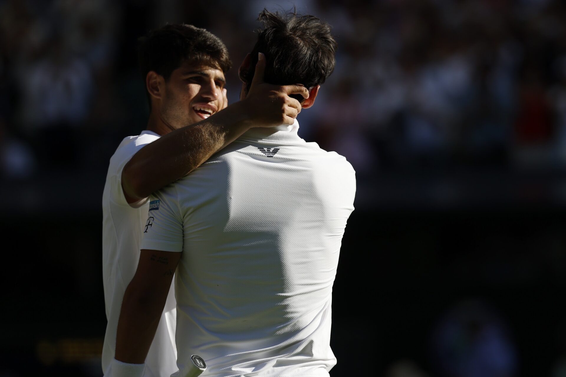 Carlos Alcaraz (ESP)(L) hugs Fabio Fognini (ITA)(R) after their match on day one of The Championships, Wimbledon 2025 at All England Lawn Tennis and Croquet Club.