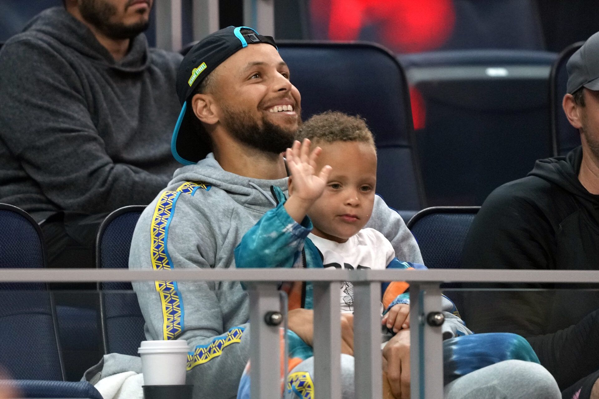Golden State Warriors guard Stephen Curry (30) sits in the stands with son Canon during the second quarter against the Sacramento Kings at the California Summer League at Chase Center.