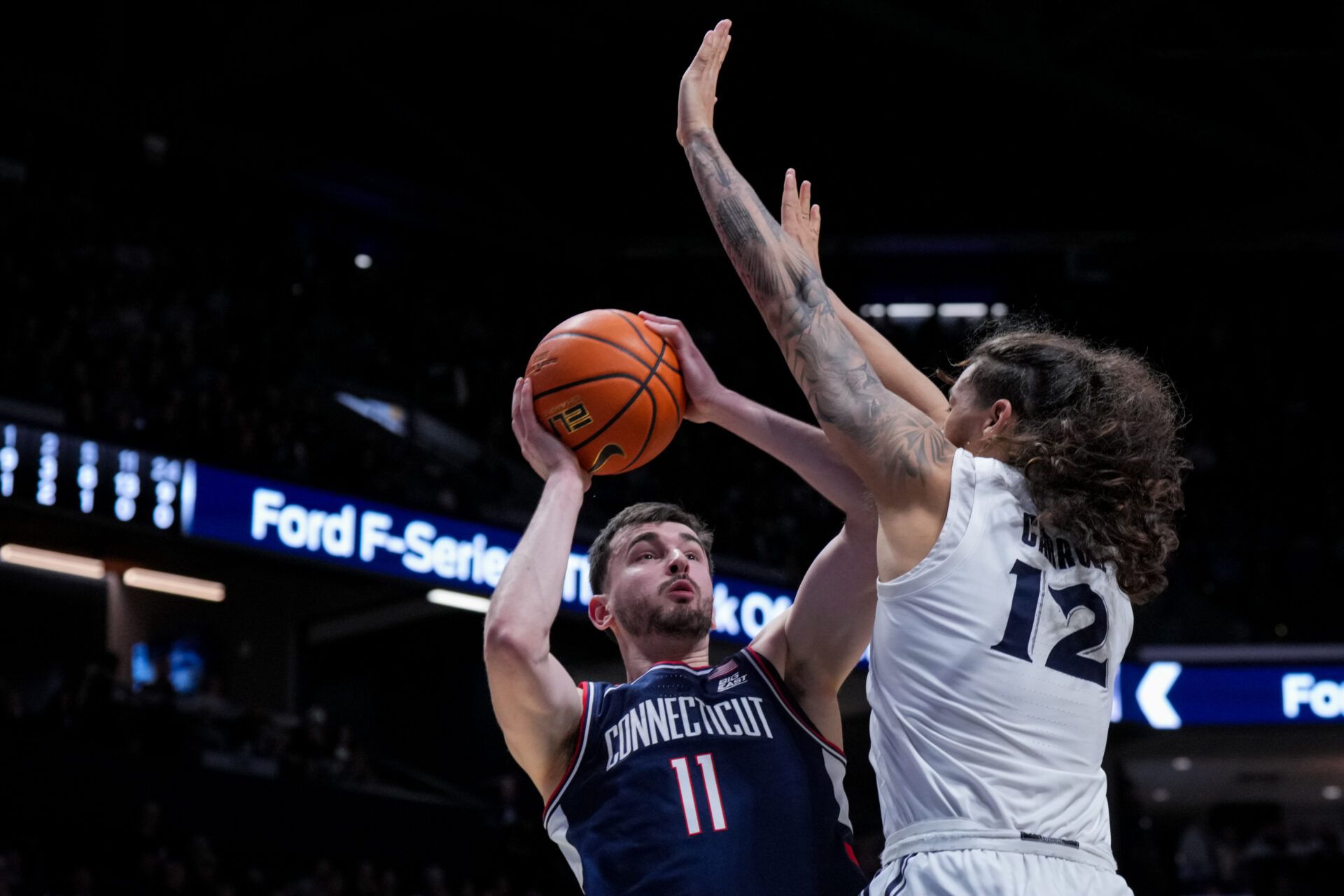 UConn Huskies forward Alex Karaban (11) shoots against Xavier Musketeers forward Tre Carroll (12) in the second half at the Cintas Center.