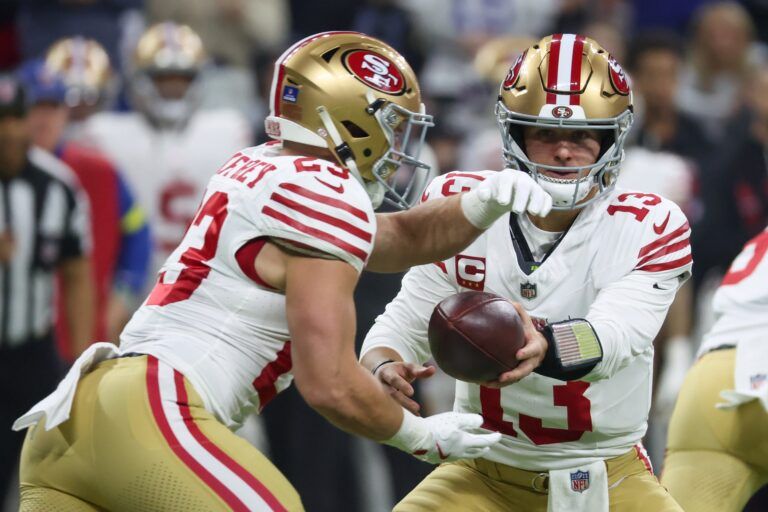 San Francisco 49ers quarterback Brock Purdy (13) hands the ball to running back Christian McCaffrey (23) against the Indianapolis Colts in the first quarter of the game at Lucas Oil Stadium.