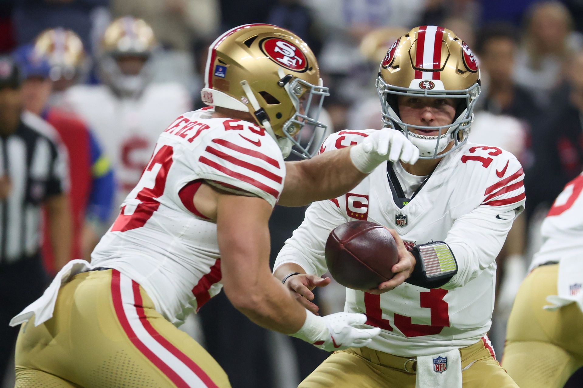 San Francisco 49ers quarterback Brock Purdy (13) hands the ball to running back Christian McCaffrey (23) against the Indianapolis Colts in the first quarter of the game at Lucas Oil Stadium.