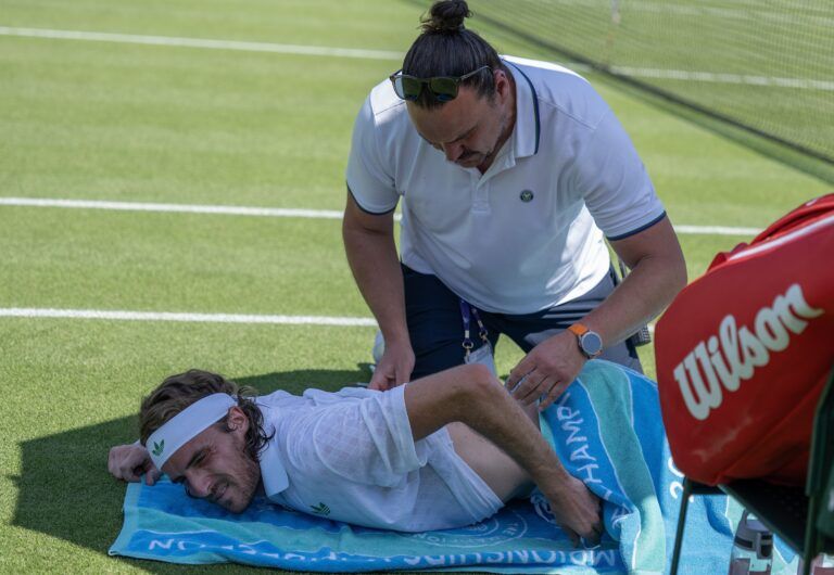 Stefanos Tsitsipas of Greece receives treatment during a medical time out during his match against Valentin Royer of France on day one at the All England Lawn Tennis and Croquet Club.