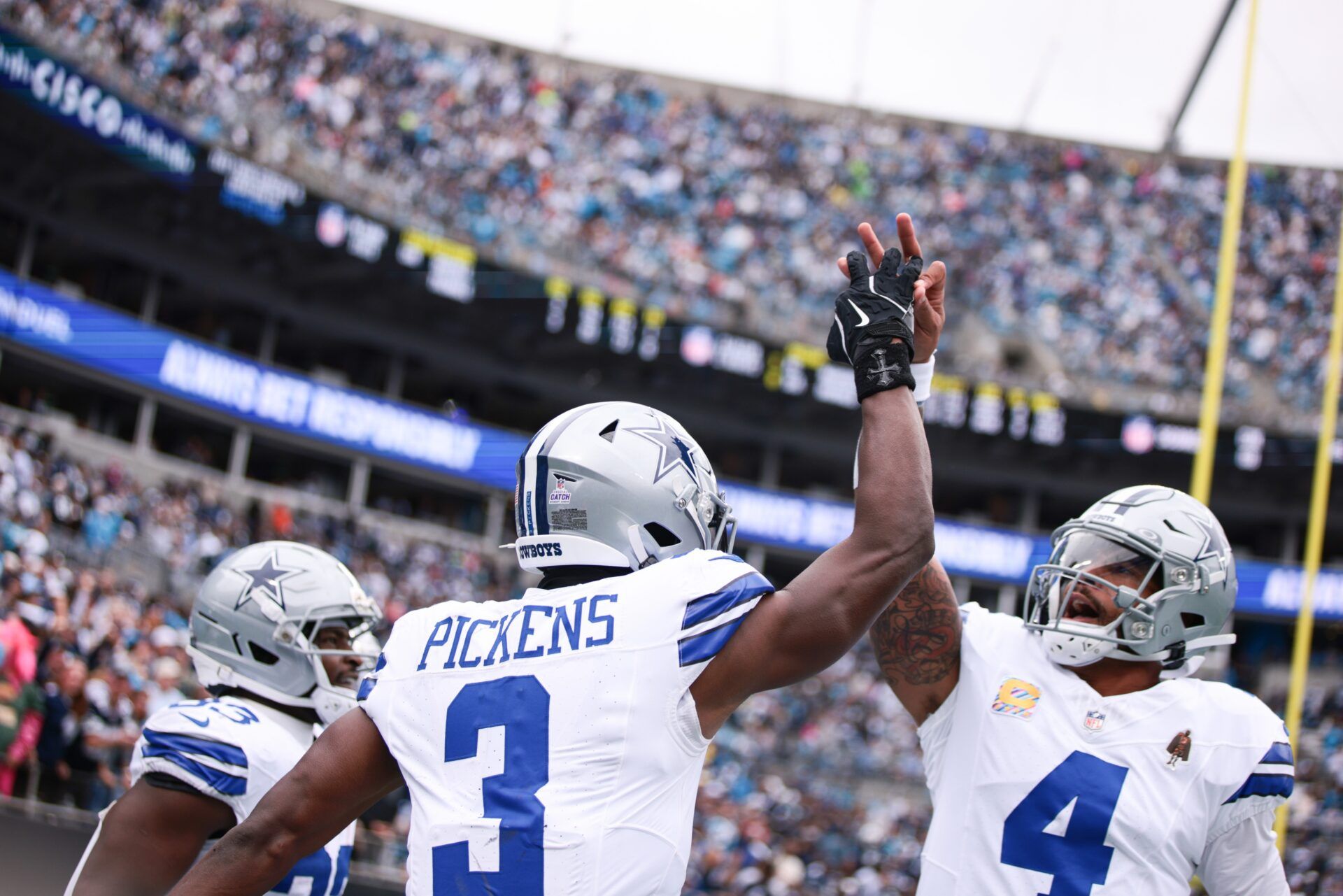 Dallas Cowboys wide receiver George Pickens (3) celebrates with quarterback Dak Prescott (4) during the first half at Bank of America Stadium.