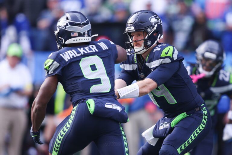 Seattle Seahawks quarterback Sam Darnold (14) hands the ball off to Seattle Seahawks running back Kenneth Walker III (9) during the first quarter at Lumen Field.