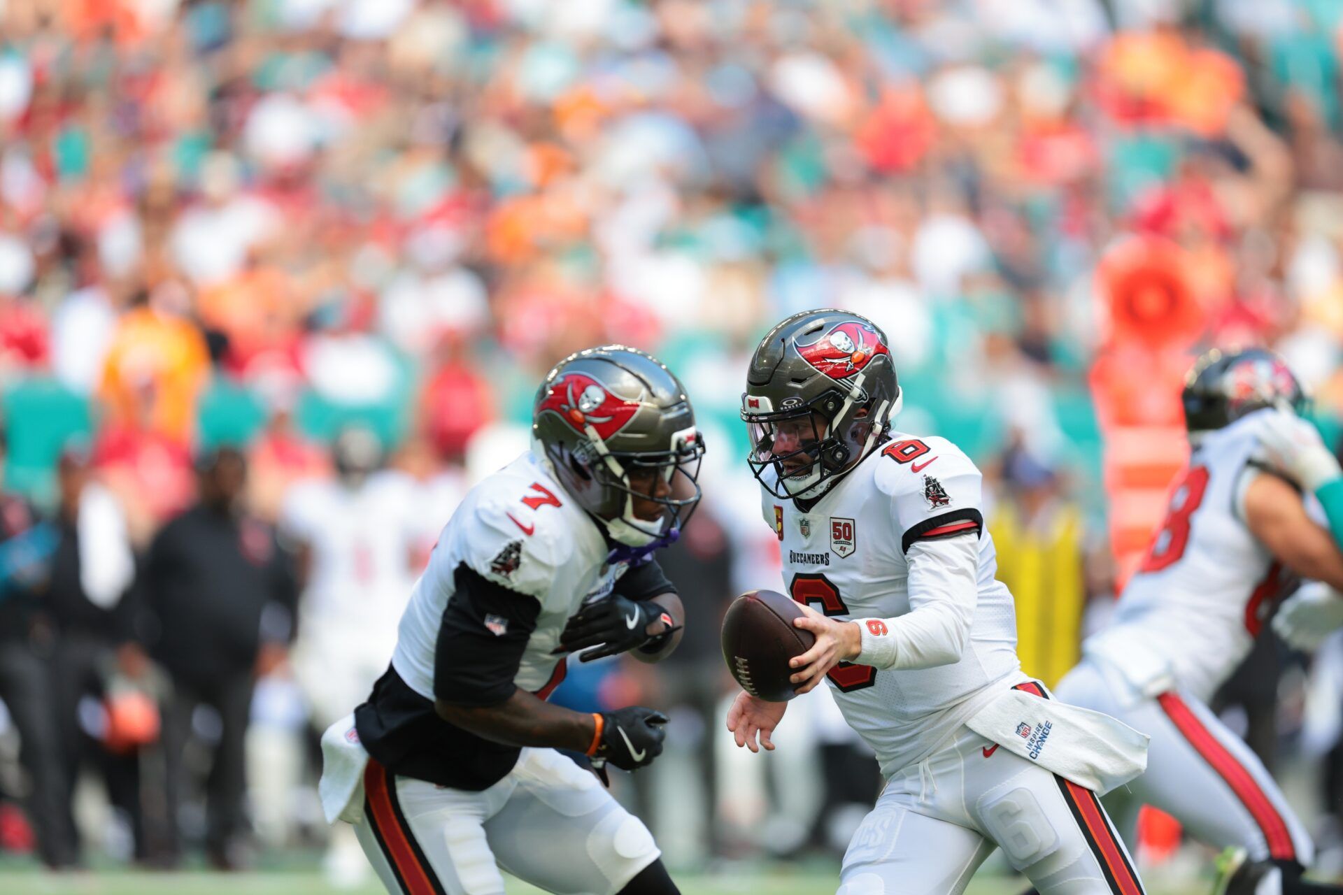 Tampa Bay Buccaneers quarterback Baker Mayfield (6) fakes a hand-off to running back Bucky Irving (7) during the first quarter against the Miami Dolphins at Hard Rock Stadium.