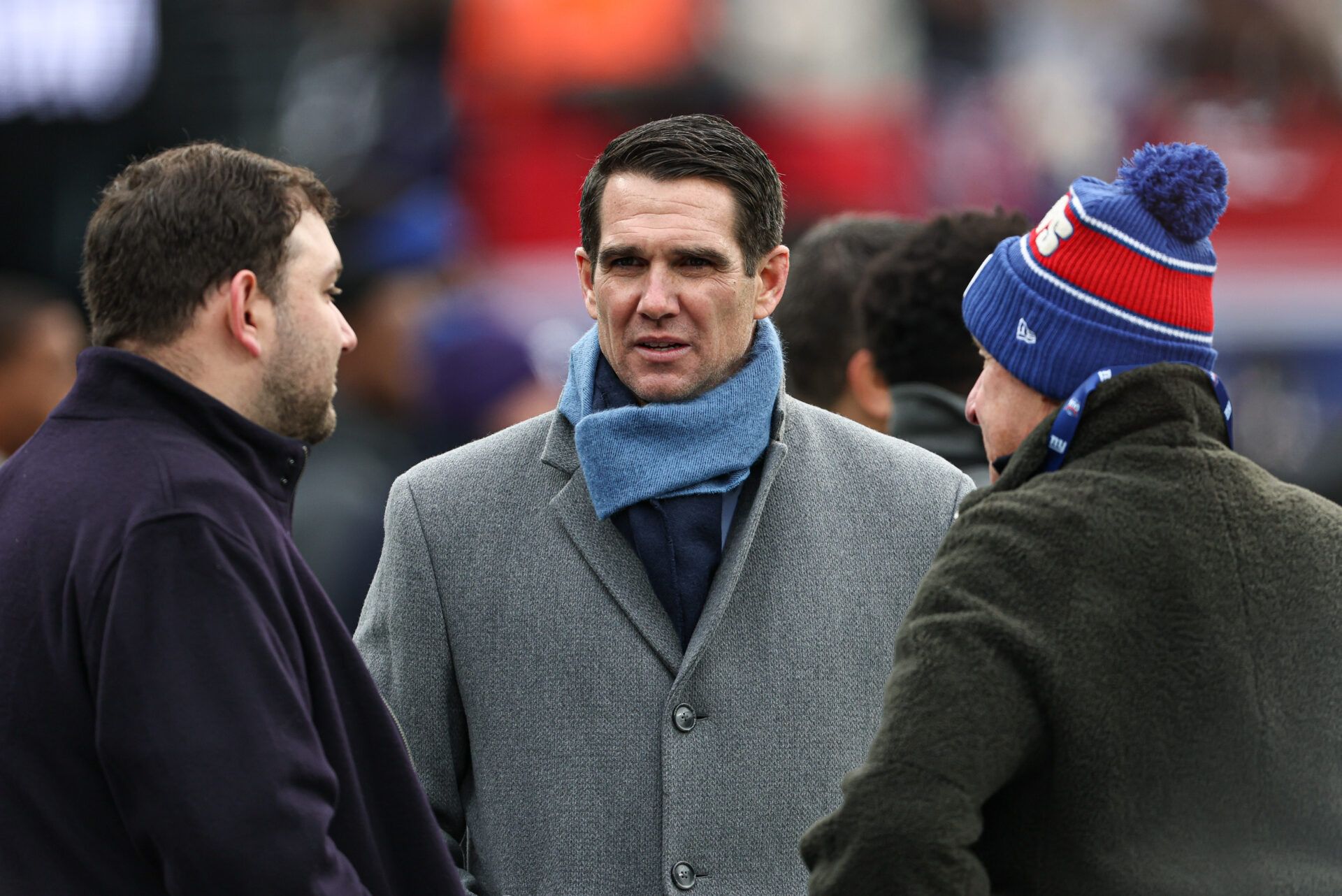 New York Giants general manager Joe Schoen, center, on the field before the game against the Baltimore Ravens at MetLife Stadium.