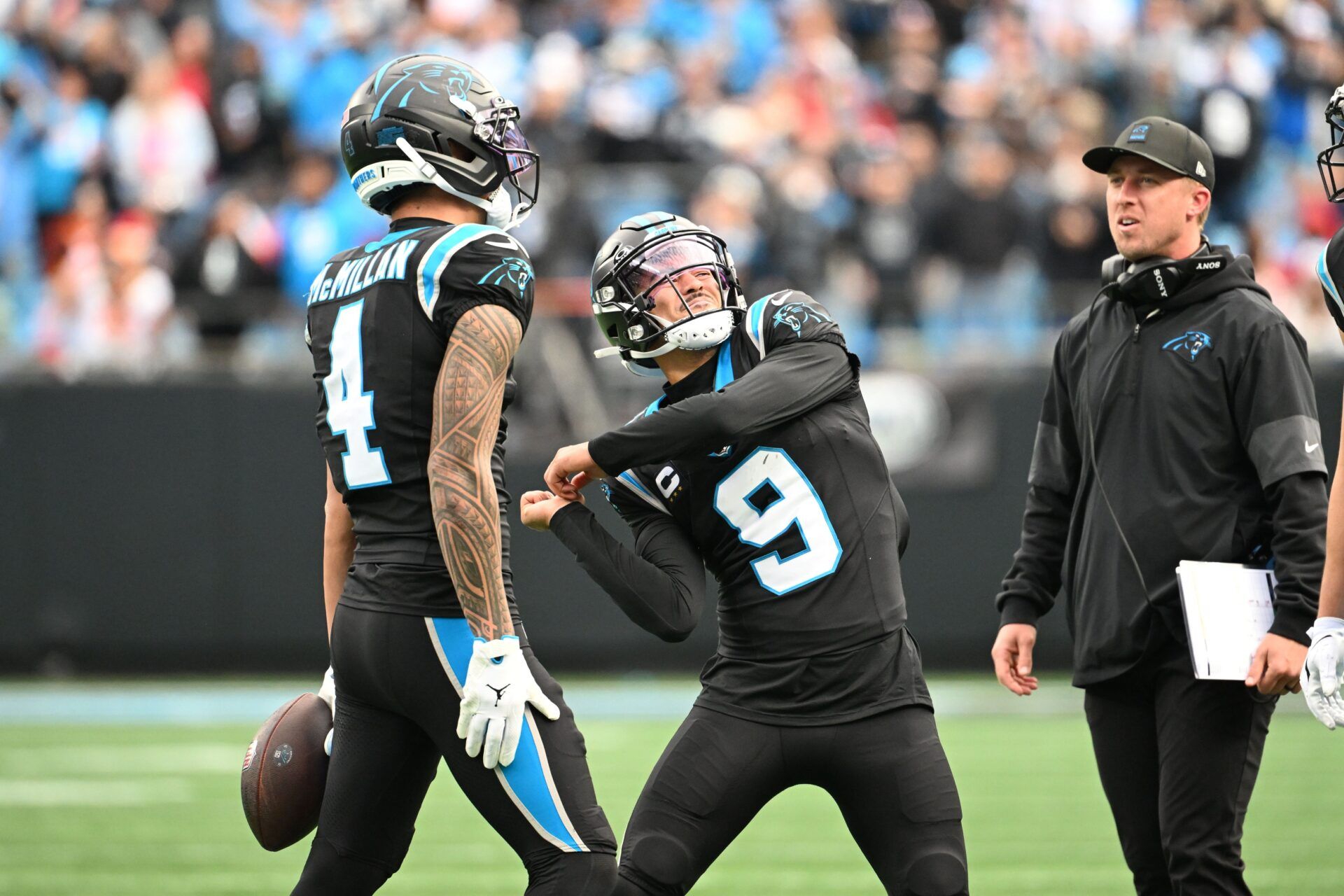Carolina Panthers wide receiver Tetairoa McMillan (4) throws an imaginary ball that quarterback Bryce Young (9) hits into the crowd after scoring a touchdown in the second quarter at Bank of America Stadium.