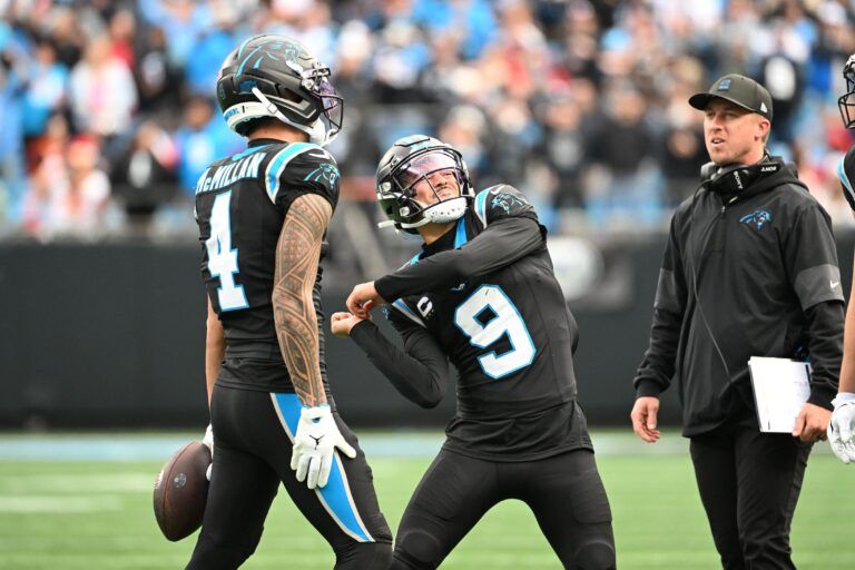 Carolina Panthers wide receiver Tetairoa McMillan (4) throws an imaginary ball that quarterback Bryce Young (9) hits into the crowd after scoring a touchdown in the second quarter at Bank of America Stadium.