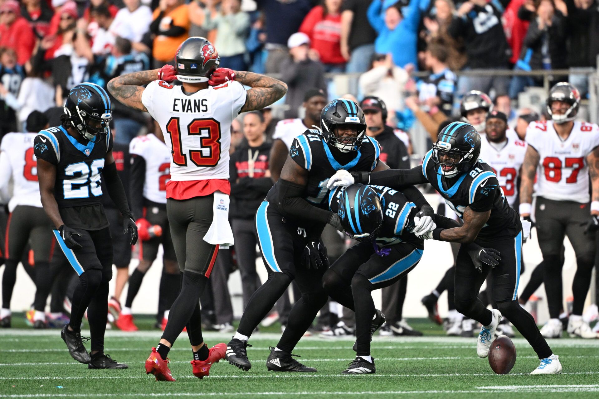 Carolina Panthers safety Lathan Ransom (22) celebrates with cornerback Chau Smith-Wade (26) and linebacker Nic Scourton (11) and safety Nick Scott (21) after intercepting the ball to seal the victory in the fourth quarter as Tampa Bay Buccaneers wide receiver Mike Evans (13) looks on at Bank of America Stadium.