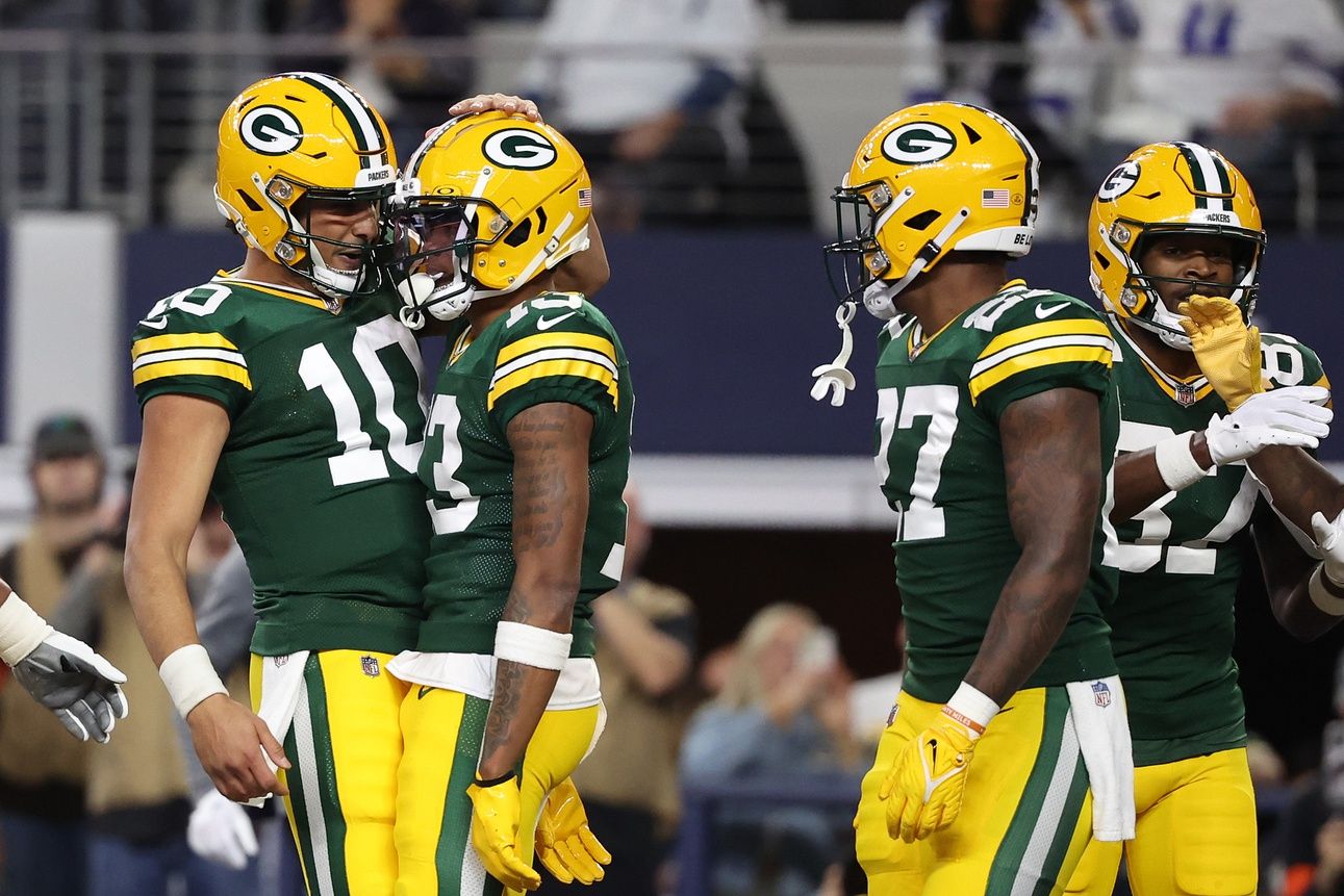 Green Bay Packers quarterback Jordan Love (10) reacts with wide receiver Dontayvion Wicks (13) after a touchdown catch in the first half of the 2024 NFC wild card game at AT&T Stadium.