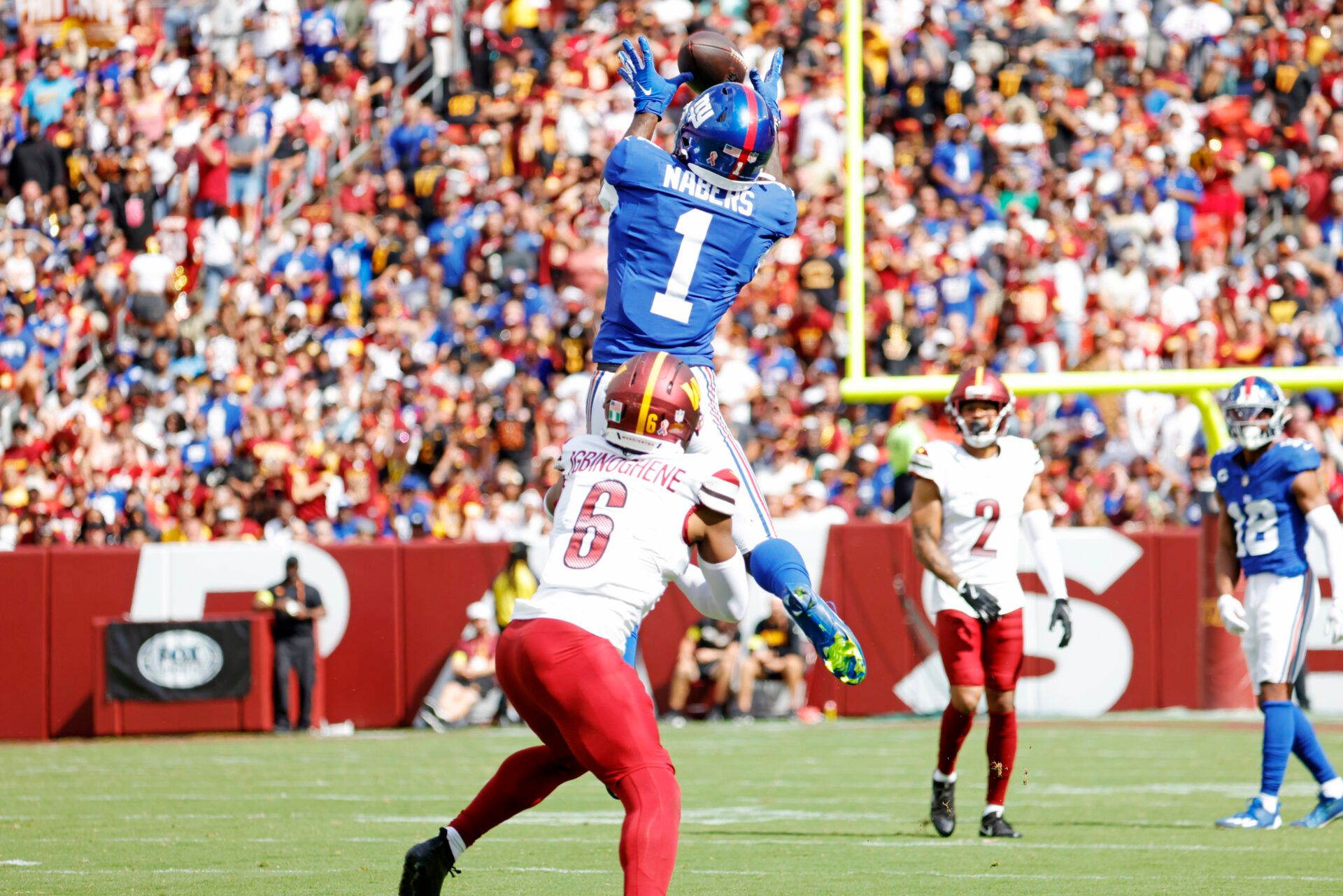 New York Giants wide receiver Malik Nabers (1) makes a catch above Washington Commanders cornerback Noah Igbinoghene (6) during the third quarter at Northwest Stadium.