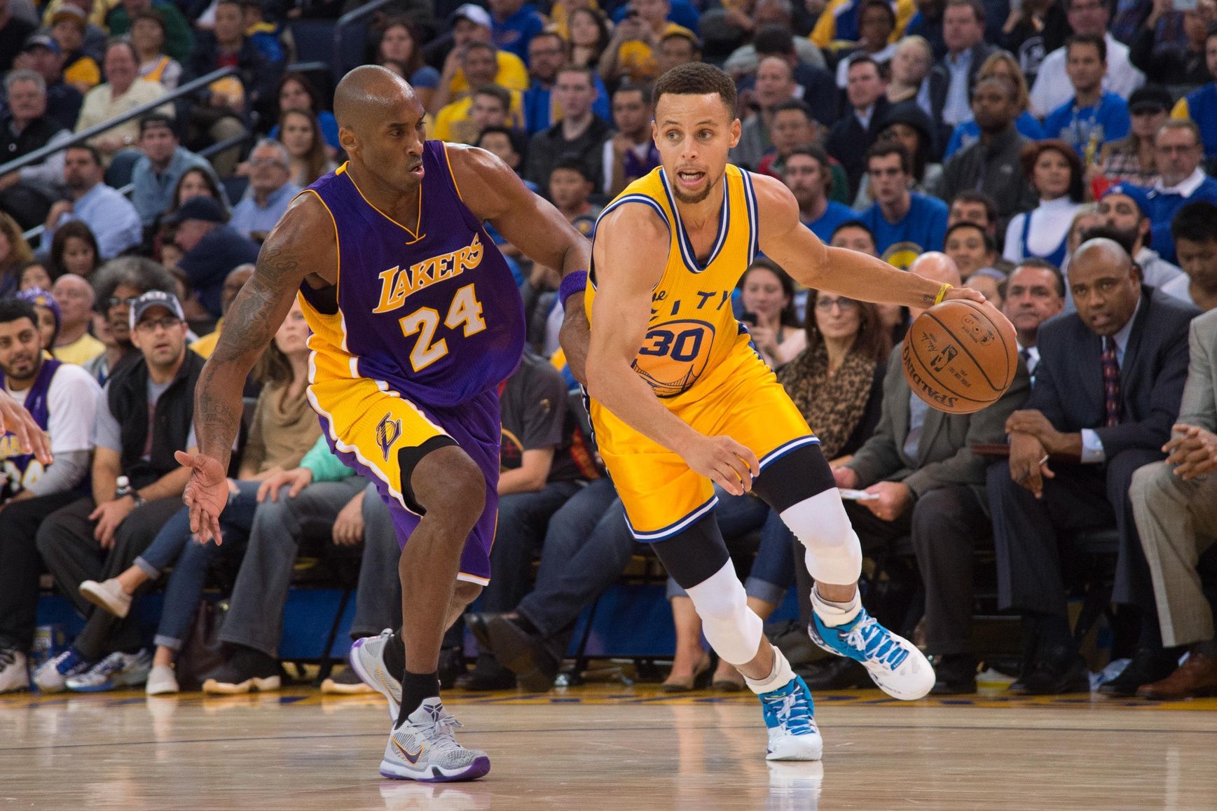 Golden State Warriors guard Stephen Curry (30) dribbles the basketball against Los Angeles Lakers forward Kobe Bryant (24) during the third quarter at Oracle Arena. The Warriors defeated the Lakers 111-77.