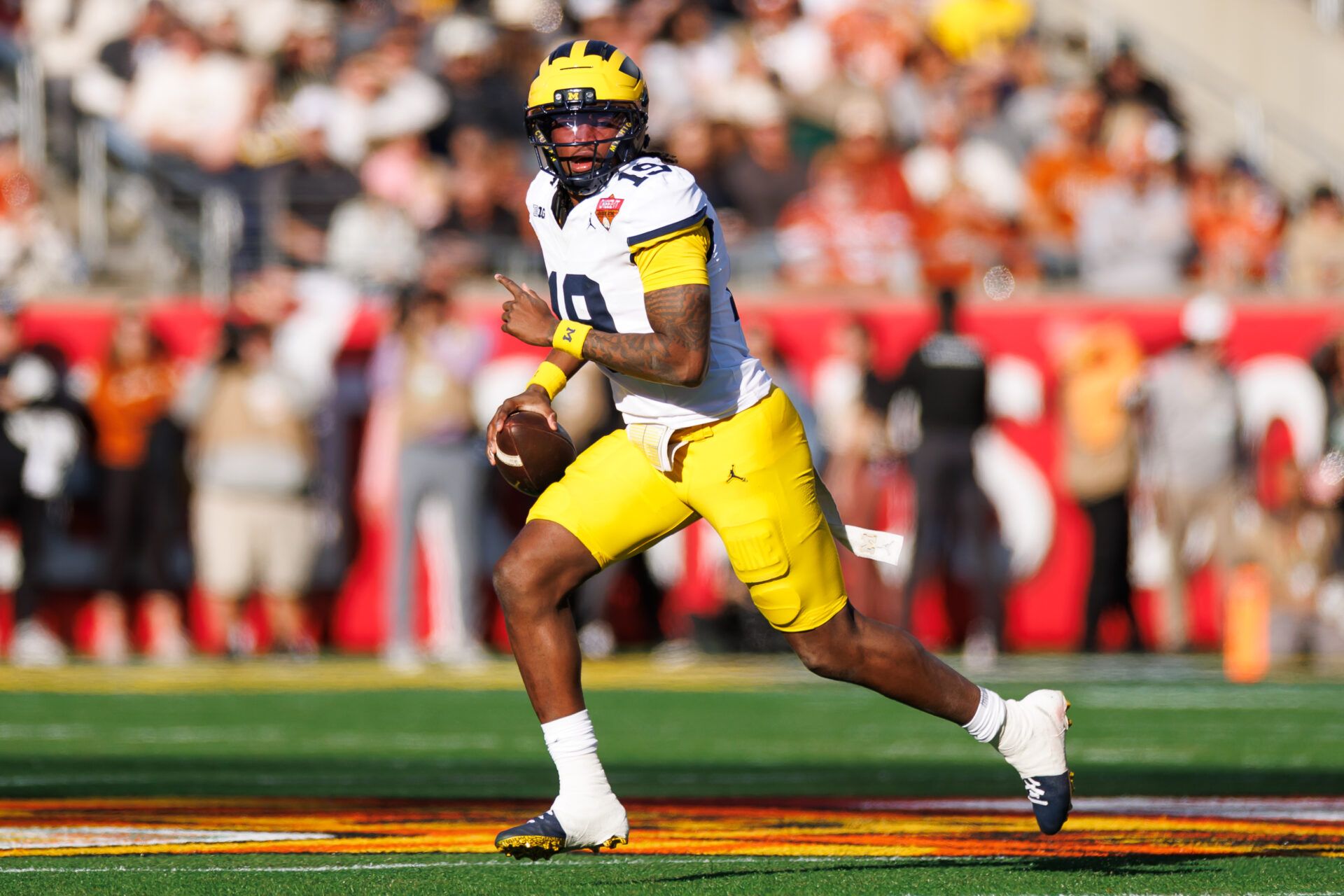 Michigan Wolverines quarterback Bryce Underwood (19) looks to throw on the run against the Texas Longhorns during the first half at Camping World Stadium.