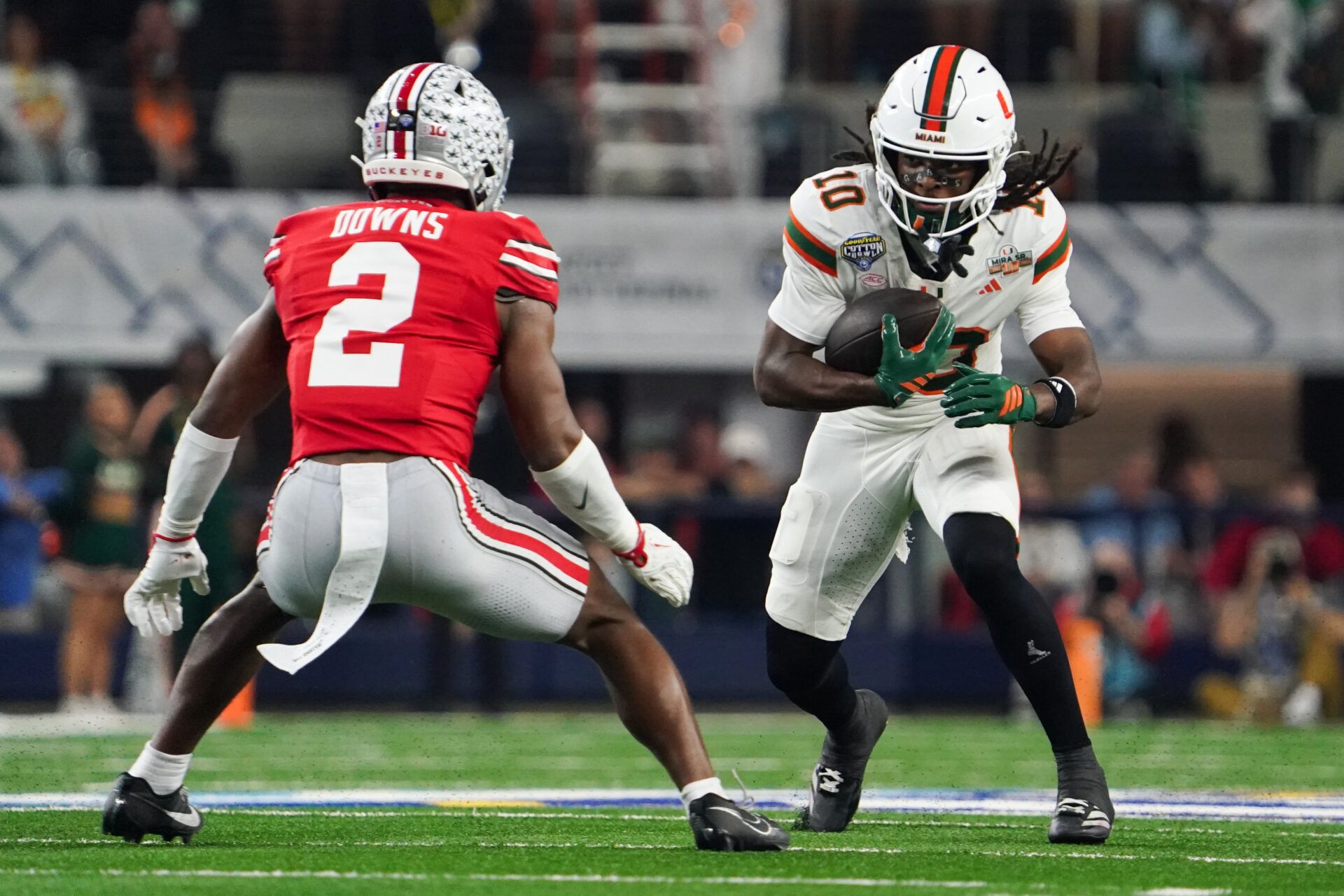Miami Hurricanes linebacker Raul Aguirre Jr. (10) moves with the ball while defended by Ohio State Buckeyes safety Caleb Downs (2) in the first quarter during the 2025 Cotton Bowl and quarterfinal game of the College Football Playoff at AT&T Stadium.