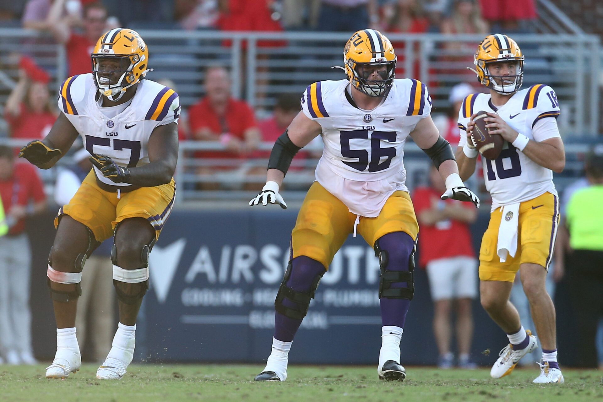 LSU Tigers offensive lineman Carius Curne (57) and offensive lineman Josh Thompson (56) block for quarterback Garrett Nussmeier (18) during the fourth quarter against the Mississippi Rebels at Vaught-Hemingway Stadium.