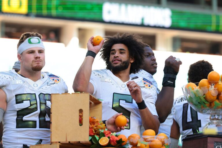 Oregon Ducks linebacker Devon Jackson (26) and quarterback Dante Moore (5) celebrate following the 2025 Orange Bowl and quarterfinal game of the College Football Playoff against the Texas Tech Red Raiders at Hard Rock Stadium.