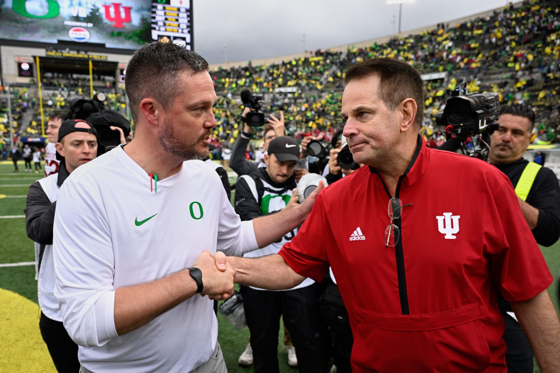 Oregon Ducks head coach Dan Lanning shakes hands with Indiana Hoosiers head coach Curt Cignetti after Indiana defeated Oregon by the score of 30-20 at Autzen Stadium.
